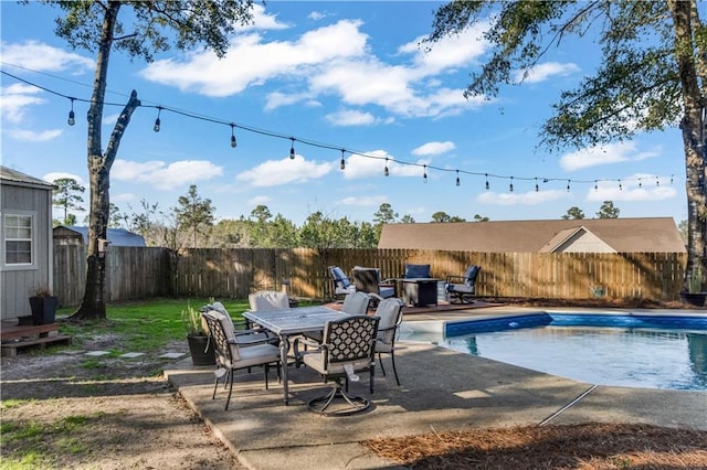 view of pool featuring a patio area, a fenced backyard, a fenced in pool, and outdoor dining space