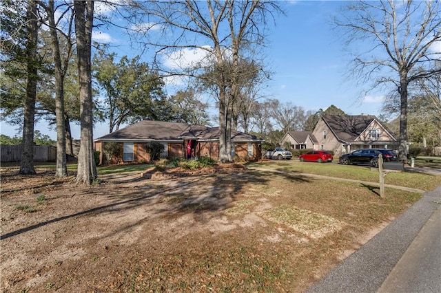 view of front of property with dirt driveway, fence, and a front yard