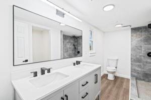 bathroom with a shower, wood-type flooring, vanity, and toilet