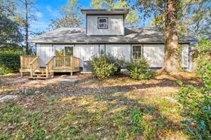 rear view of house featuring a wooden deck