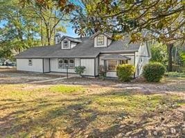 rear view of property featuring a lawn