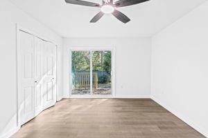 unfurnished bedroom with hardwood / wood-style floors, ceiling fan, and access to exterior