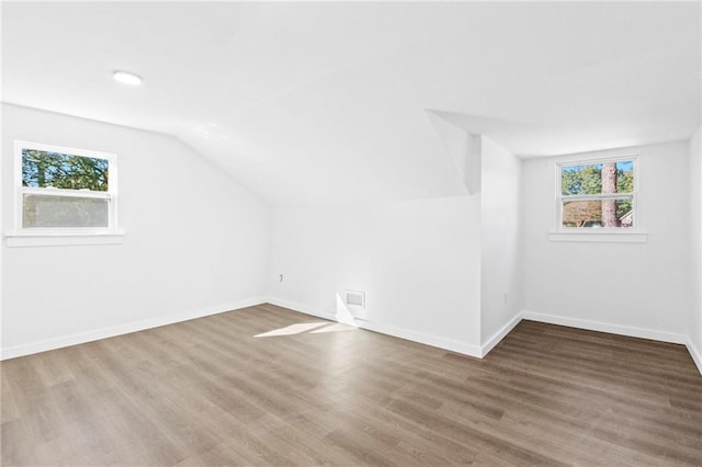 additional living space featuring hardwood / wood-style flooring and vaulted ceiling