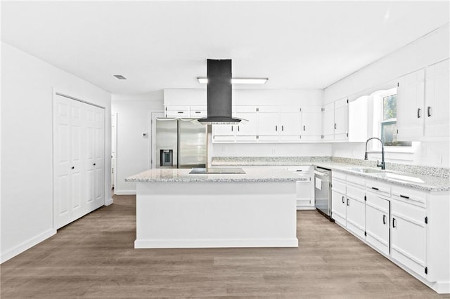 kitchen featuring island exhaust hood, light wood-type flooring, stainless steel appliances, and a kitchen island