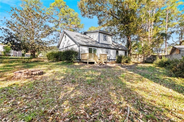 rear view of house with a wooden deck and a yard