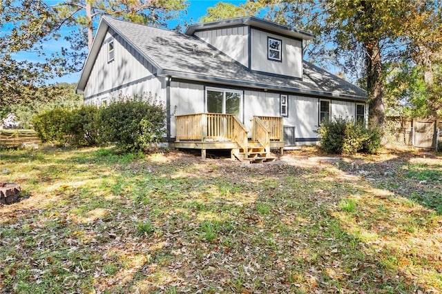 back of house featuring a lawn and a wooden deck