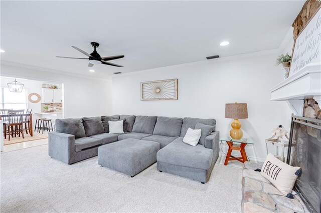 carpeted living room featuring recessed lighting, a fireplace, a ceiling fan, visible vents, and ornamental molding