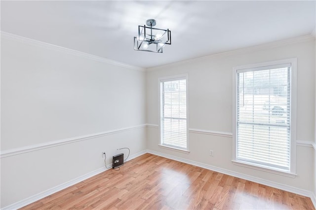 unfurnished dining area with baseboards, ornamental molding, and light wood-style floors