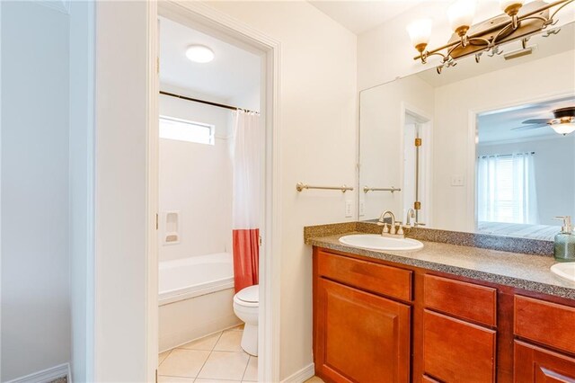 bathroom with double vanity, toilet, a sink, and tile patterned floors