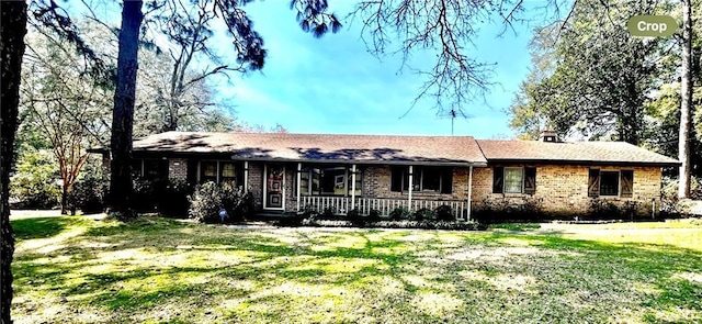 single story home with covered porch, brick siding, and a front lawn