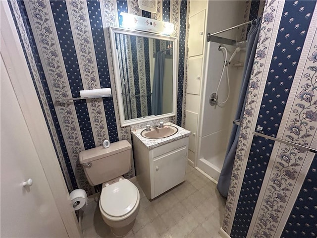 full bathroom with a stall shower, vanity, toilet, and wallpapered walls