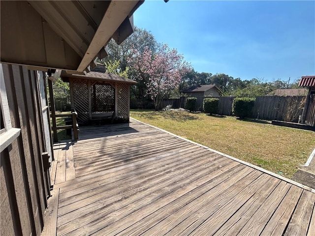 wooden deck with a fenced backyard, a yard, and a gazebo