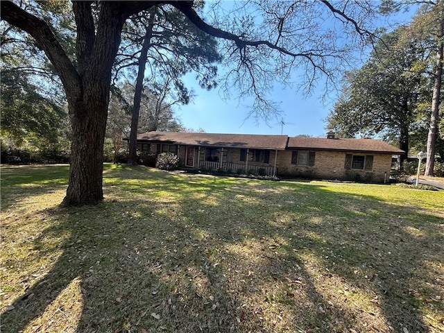 exterior space featuring brick siding and a front yard