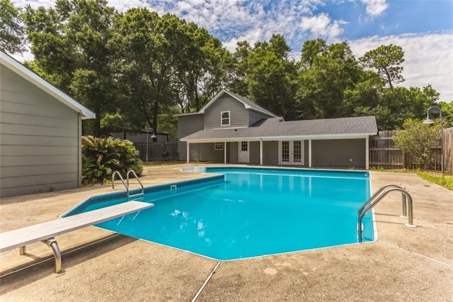 view of pool featuring a diving board, a patio area, and french doors