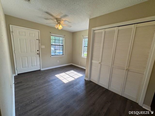 303 Ruben Ave, Saraland, AL 36571 - entrance foyer with dark wood finished floors, a textured ceiling, a ceiling fan, and baseboards