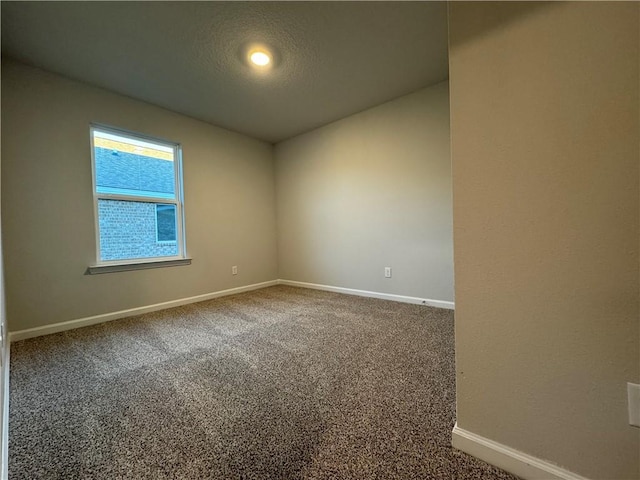 unfurnished room with carpet and a textured ceiling