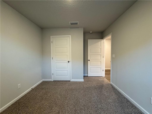 unfurnished bedroom featuring carpet, a textured ceiling, and a closet