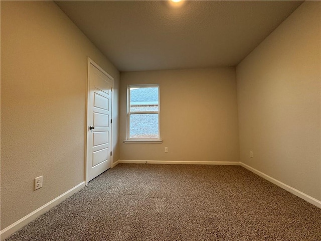 spare room featuring carpet flooring and a textured ceiling