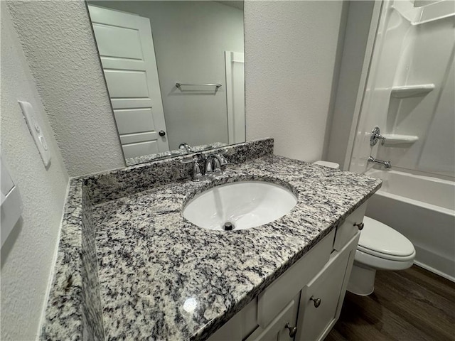 full bathroom featuring wood-type flooring, vanity, toilet, and tub / shower combination