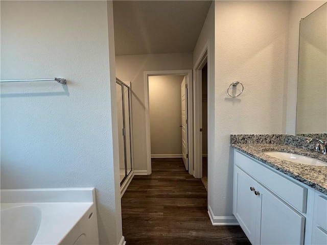 bathroom featuring vanity, wood-type flooring, and shower with separate bathtub