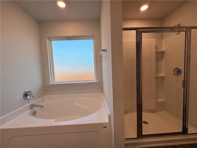 bathroom featuring shower with separate bathtub