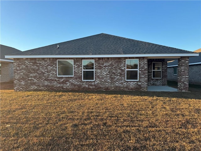 back of property with a lawn and a patio area