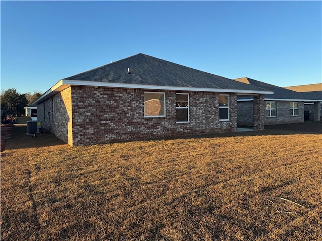 back of house featuring central AC unit and a yard