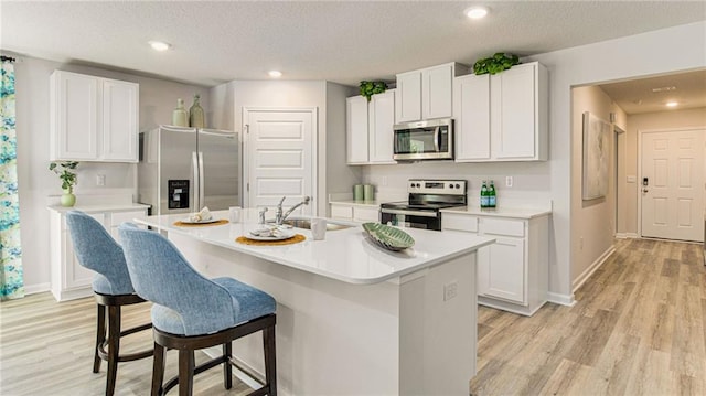 kitchen featuring a center island with sink, white cabinets, sink, and stainless steel appliances