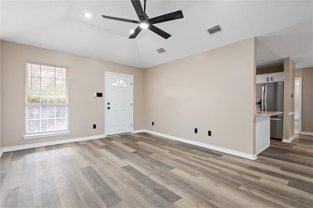 interior space featuring ceiling fan, wood-type flooring, and lofted ceiling