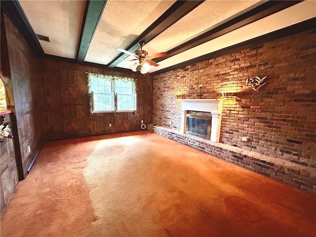 1113 Carre Dr W, Mobile, AL 36618 - unfurnished living room with wooden walls, carpet, a brick fireplace, beamed ceiling, and a ceiling fan