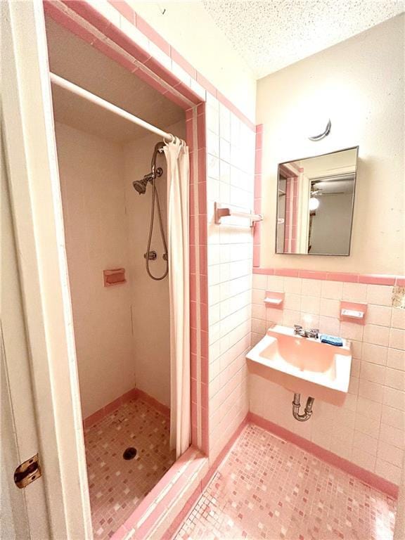 1113 Carre Dr W, Mobile, AL 36618 - full bath featuring a stall shower, tile walls, a textured ceiling, and a wainscoted wall