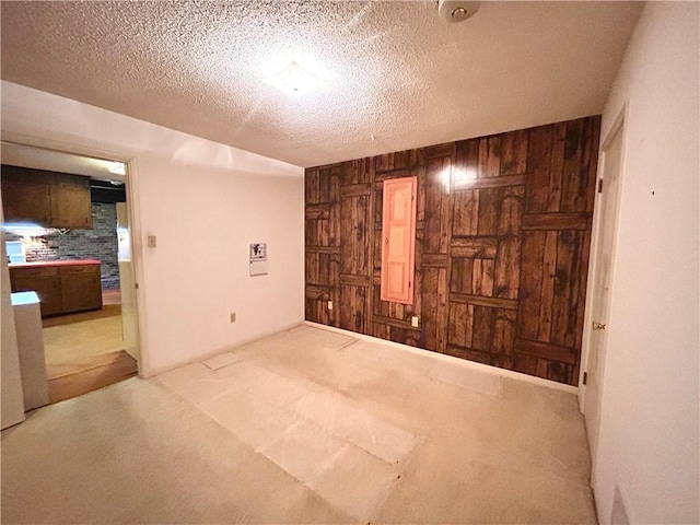1113 Carre Dr W, Mobile, AL 36618 - spare room featuring wooden walls, carpet flooring, and a textured ceiling