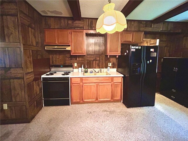 1113 Carre Dr W, Mobile, AL 36618 - kitchen featuring range with gas stovetop, black refrigerator with ice dispenser, under cabinet range hood, wood walls, and beam ceiling