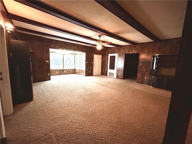 1113 Carre Dr W, Mobile, AL 36618 - unfurnished living room featuring wooden walls, beamed ceiling, carpet flooring, a textured ceiling, and a ceiling fan