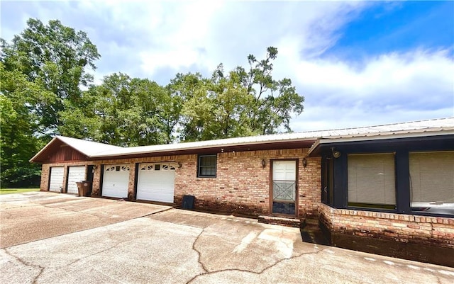 1113 Carre Dr W, Mobile, AL 36618 - ranch-style home with concrete driveway, a garage, brick siding, and a metal roof