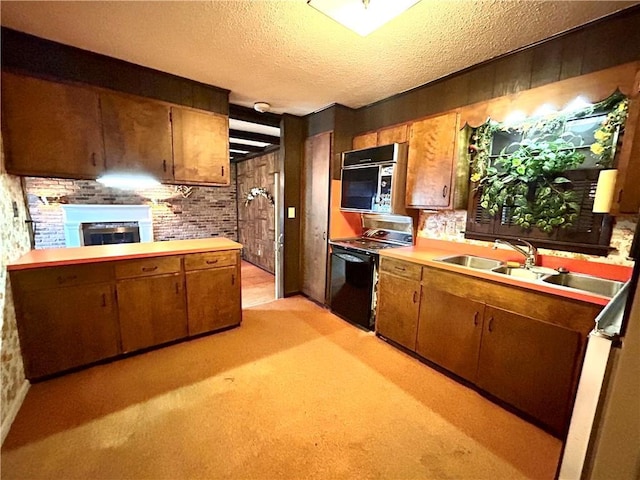 1113 Carre Dr W, Mobile, AL 36618 - kitchen with black appliances, a fireplace, a textured ceiling, light countertops, and brown cabinetry