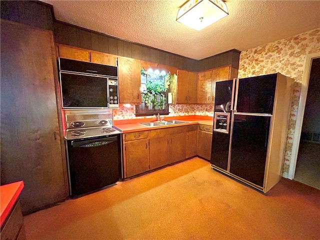 1113 Carre Dr W, Mobile, AL 36618 - kitchen featuring black appliances, a textured ceiling, light countertops, wallpapered walls, and brown cabinetry