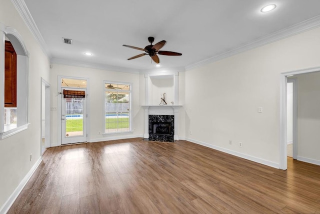8705 Floyd Crabtree Way, Semmes, AL 36575 - unfurnished living room featuring a ceiling fan, arched walkways, wood finished floors, a premium fireplace, and crown molding