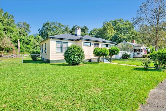 view of front of home with a front yard, fence, and a chimney