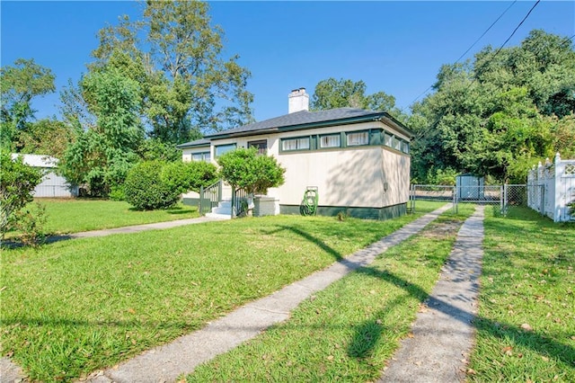 back of house featuring a chimney, fence, and a lawn