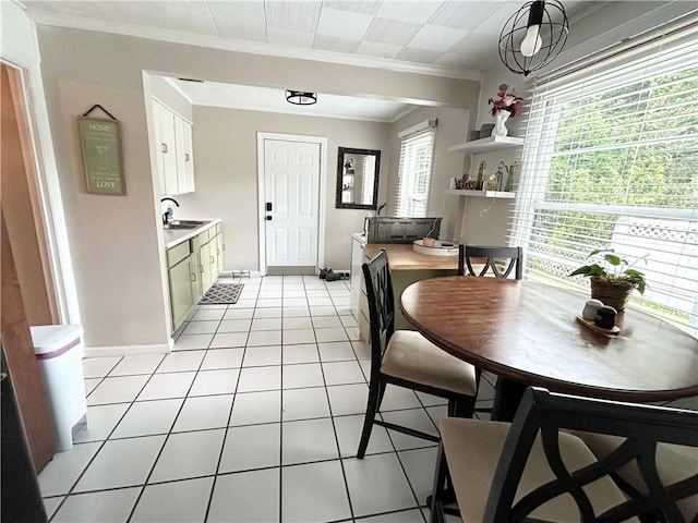 tiled dining room featuring crown molding and sink