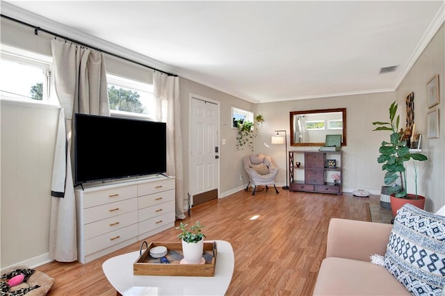 living room with crown molding, baseboards, visible vents, and light wood-type flooring