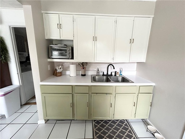 kitchen featuring light tile patterned floors, white cabinets, sink, and tasteful backsplash