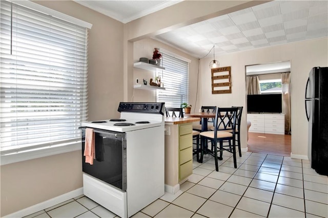 kitchen featuring crown molding, freestanding refrigerator, white electric range, and light tile patterned flooring