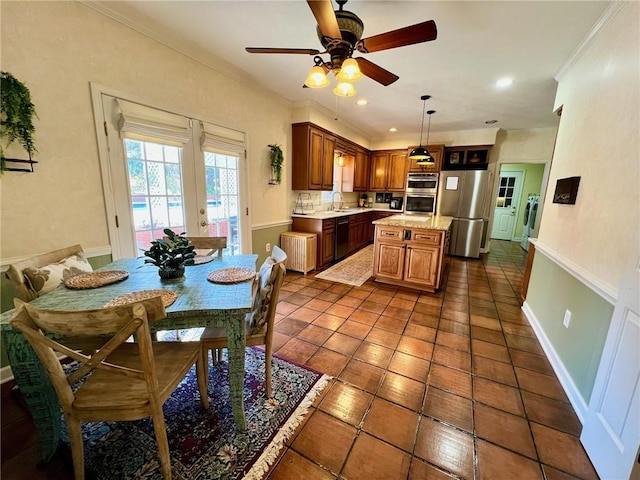 kitchen featuring washer and dryer, light countertops, ornamental molding, appliances with stainless steel finishes, and a center island