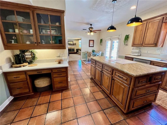 kitchen featuring a kitchen island, french doors, dishwasher, brown cabinetry, and glass insert cabinets