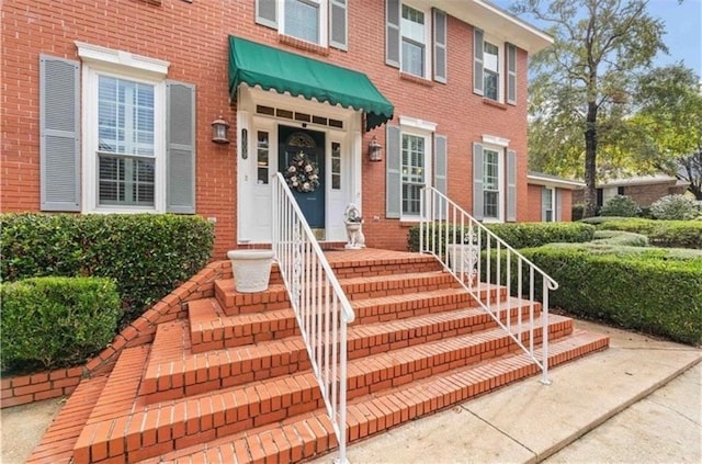 doorway to property with brick siding