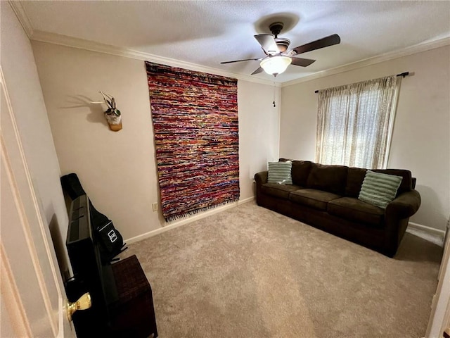 carpeted living area featuring baseboards, ornamental molding, and ceiling fan