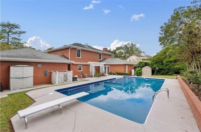 pool with an outbuilding, a storage unit, and a patio area