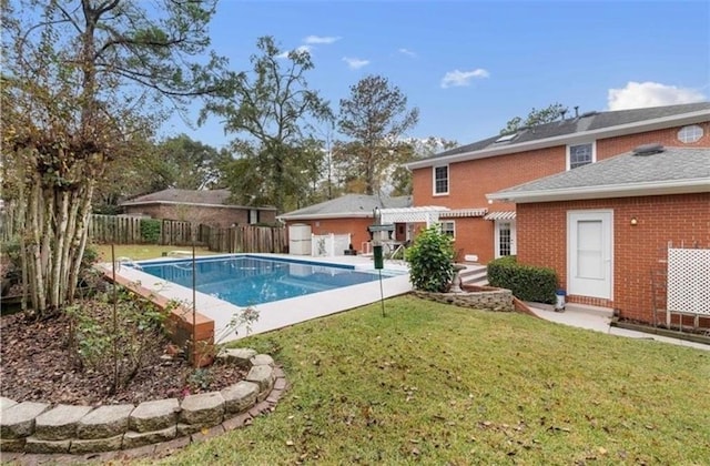 view of swimming pool with a lawn, a fenced backyard, and a fenced in pool